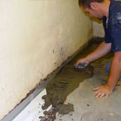 A basement waterproofer installing a perimeter drain system in Goochland