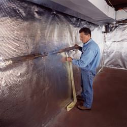 Installation of a radiant heat and vapor barrier on a basement wall in Matthews