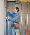 Insulated basement wall panels being placed against a concrete foundation wall in Hampton